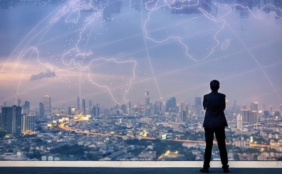 Man looking at a city skyline with impression of the whole world in sky above.